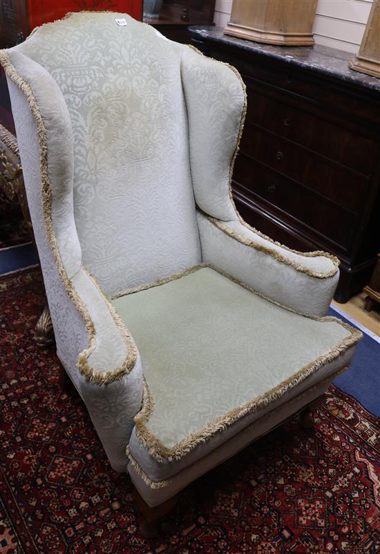 A wing armchair with pad feet